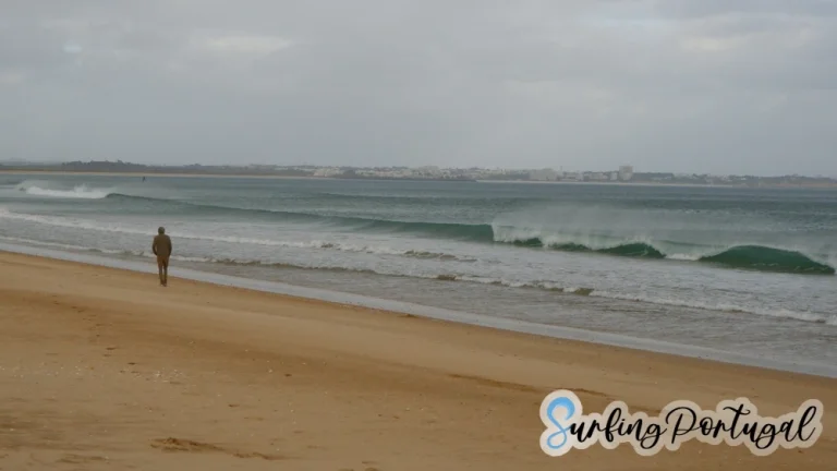 Guy walking and waves breaking at Meia Praia (Lagos)