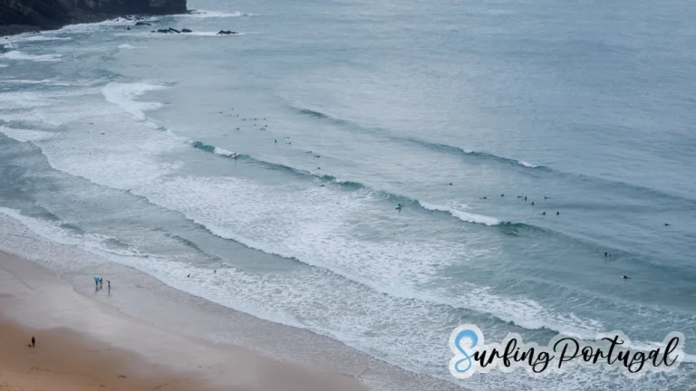 Bay of Arrifana, Portugal, on a cloudy day, with some surfers in the water