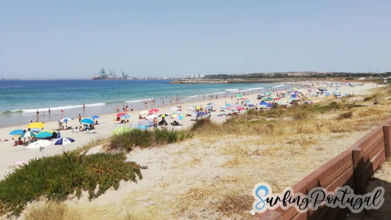 São Torpes beach on a summer day, with some surfers in the water