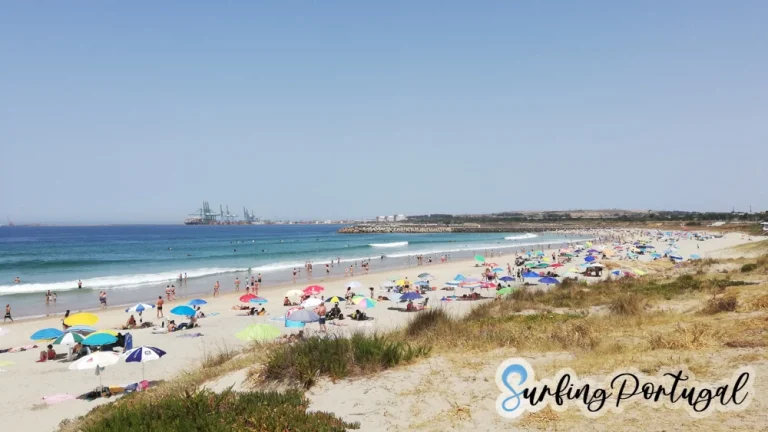 São Torpes beach on a summer day, with some surfers in the water
